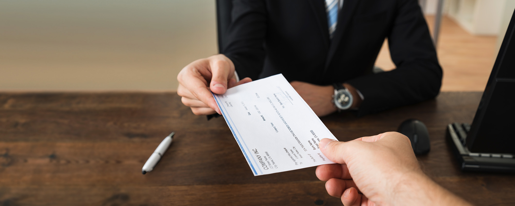 businessman giving cheque to other person