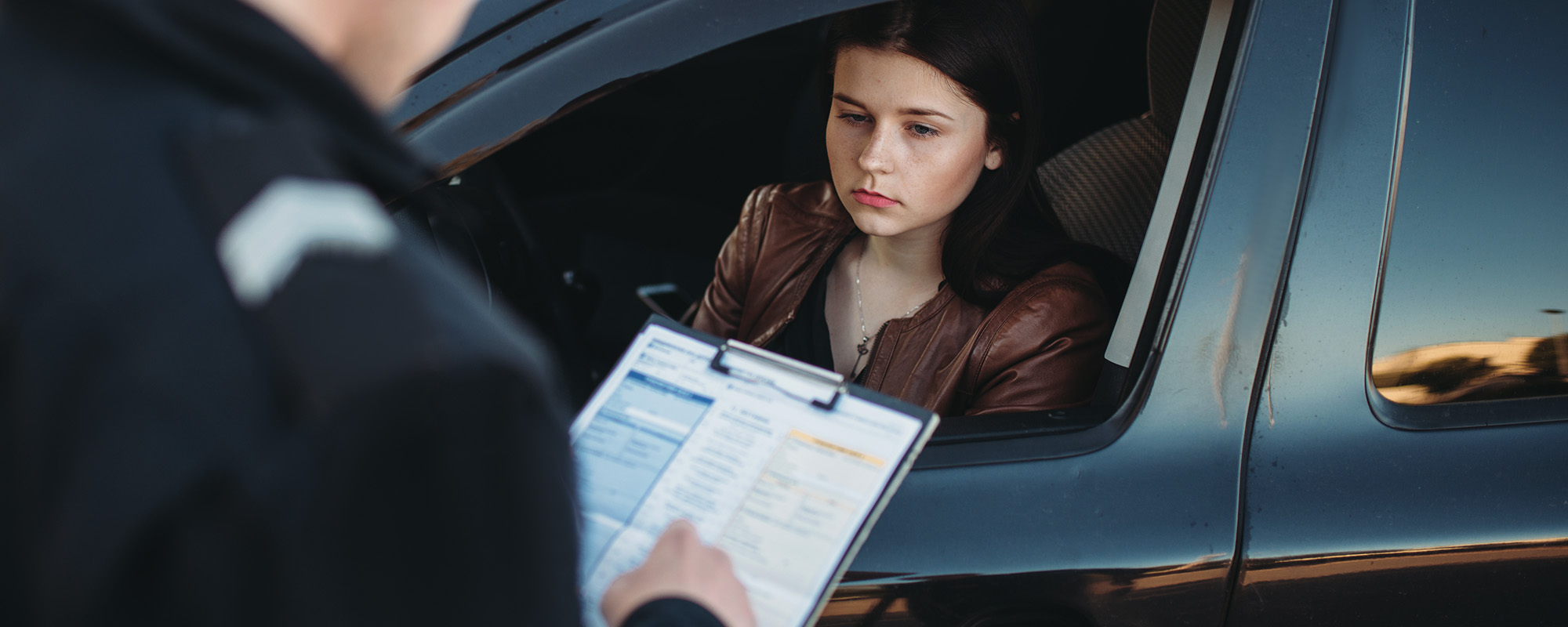 policeman in uniform writes fine to female driver