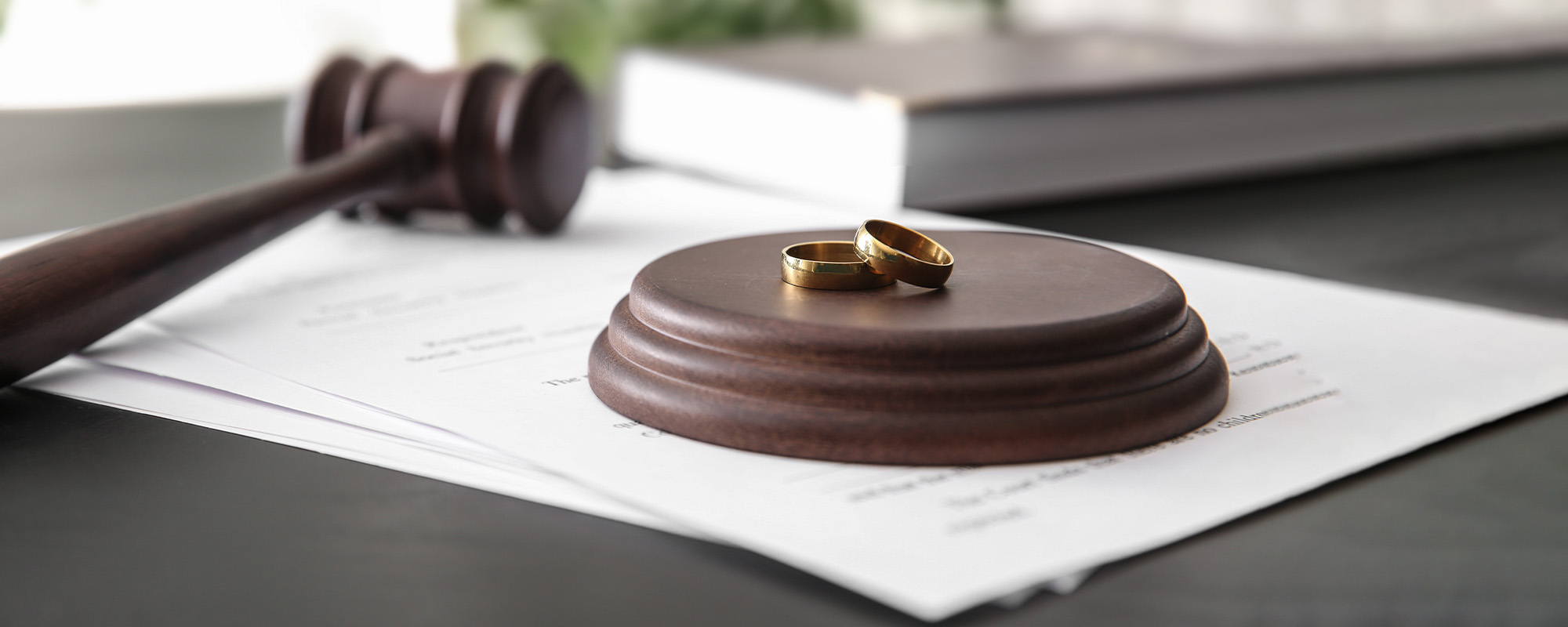 rings with decree of divorce and judge gavel on table
