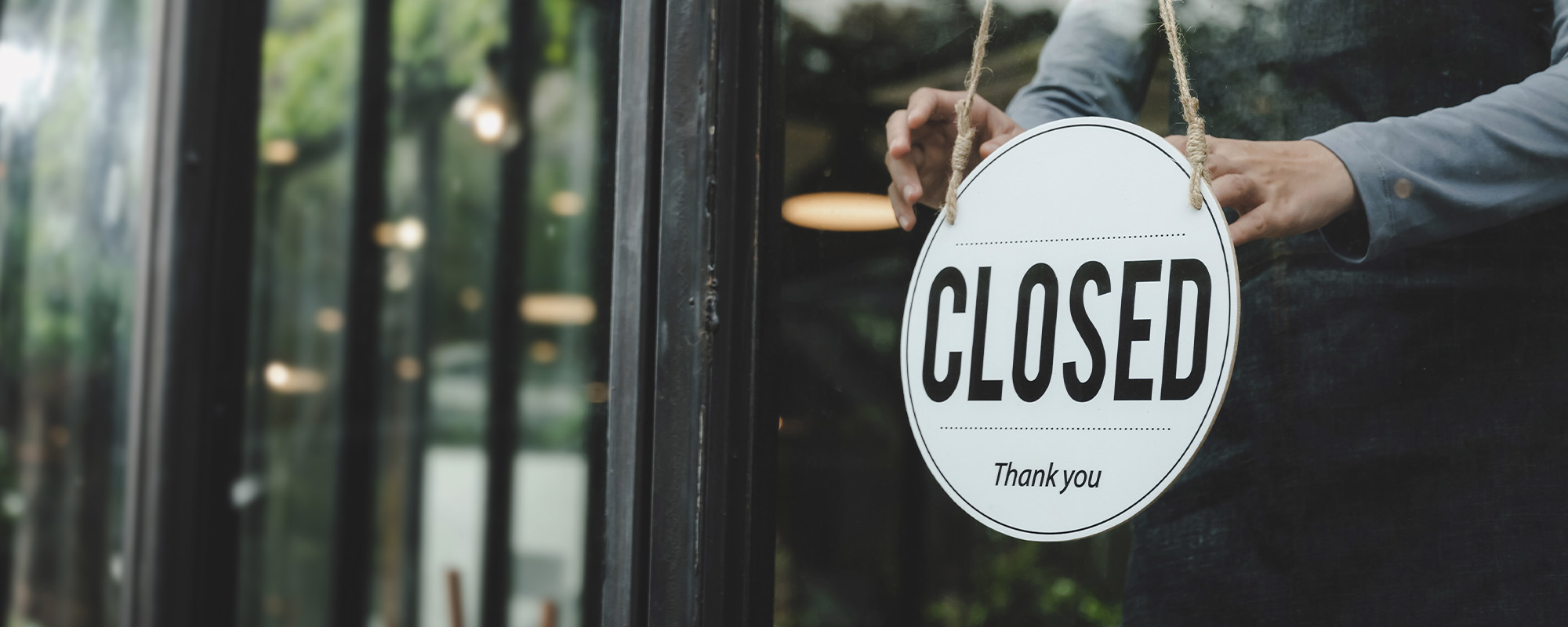 small business owner woman wearing protection face mask turning closed sign board on glass door for open cafe restaurant