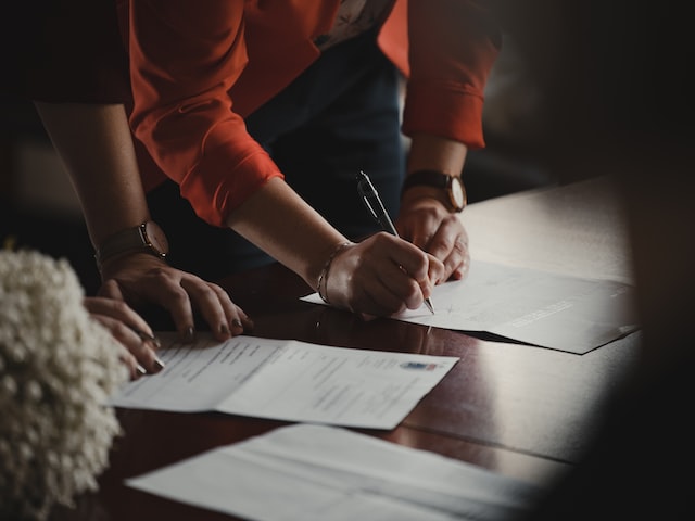 two people signing documents