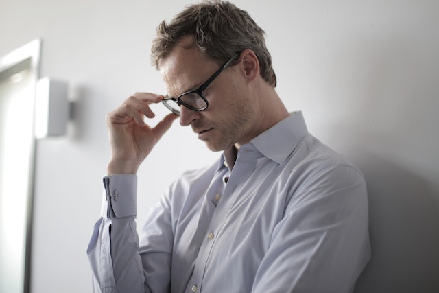 stressed man leaning against wall