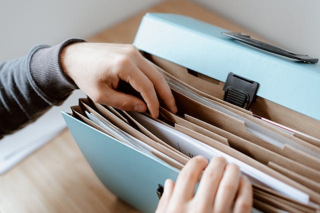 person looking through folder of documents